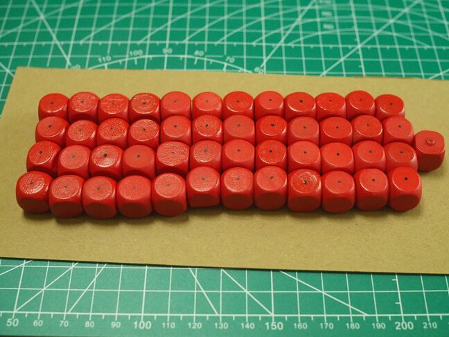 Around 50 red, painted dice with a small black dot in the center of one
face.